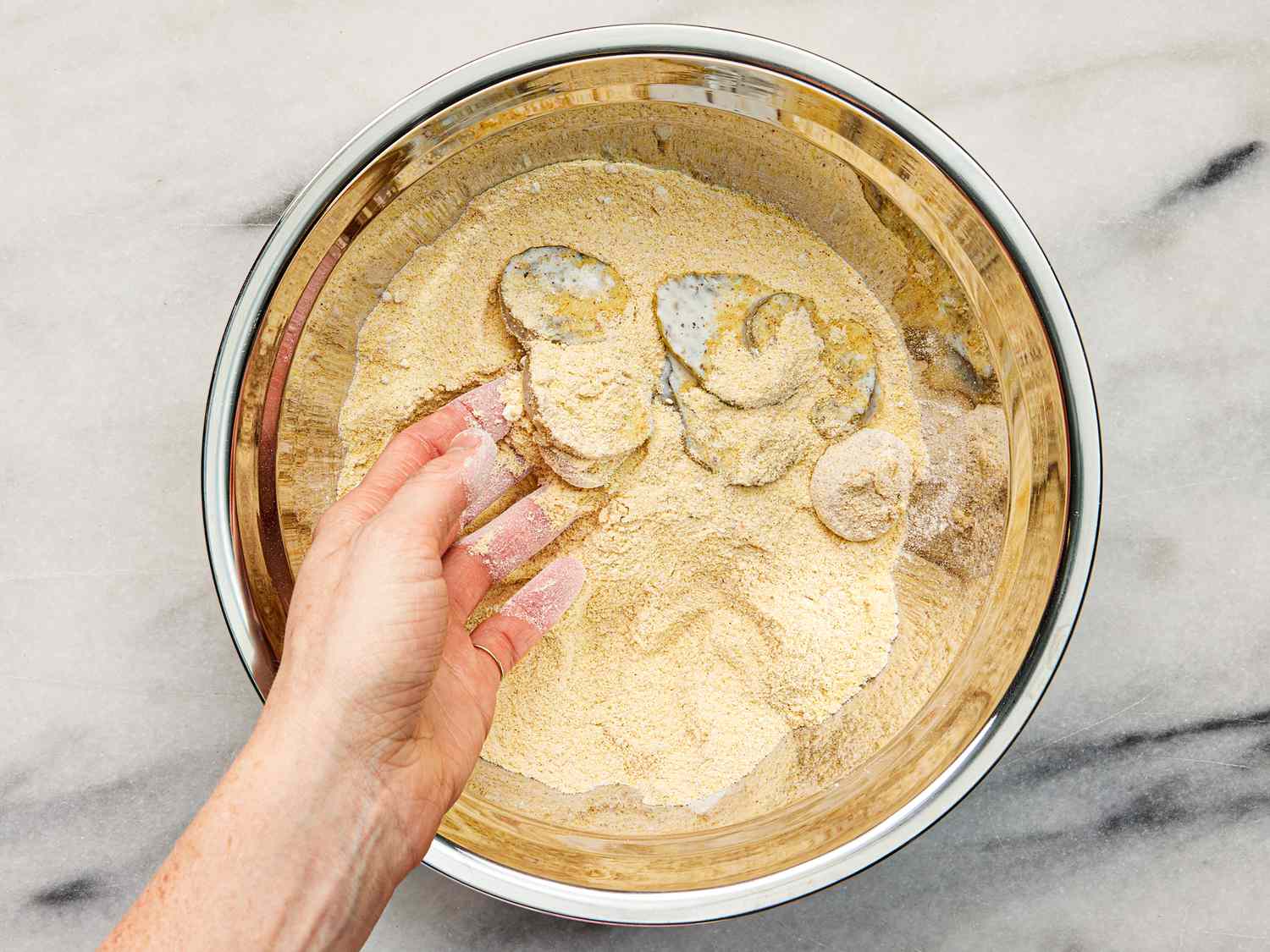 dredging pickles in dry mixture in bowl 
