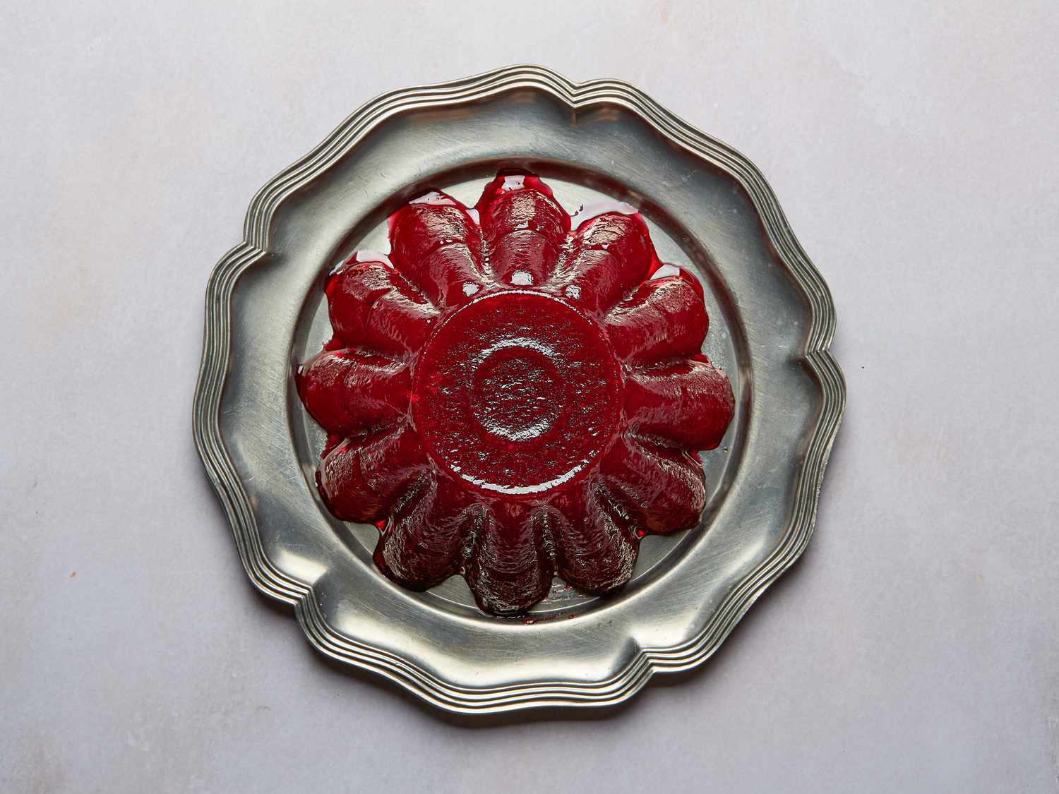 Jellied Cranberry sauce on silver platter on a grey surface