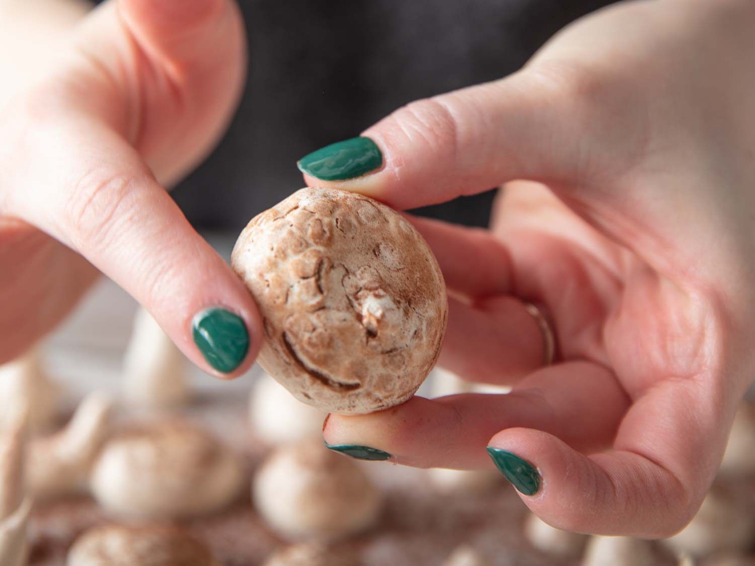 Rubbing cocoa powder into the surface of the meringue to stain it brown.