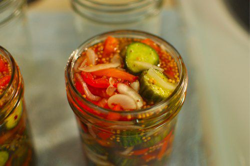 A canning jar filled with the vegetables and brine, ready to be fitted with a lid, secured with a ring, and processed.