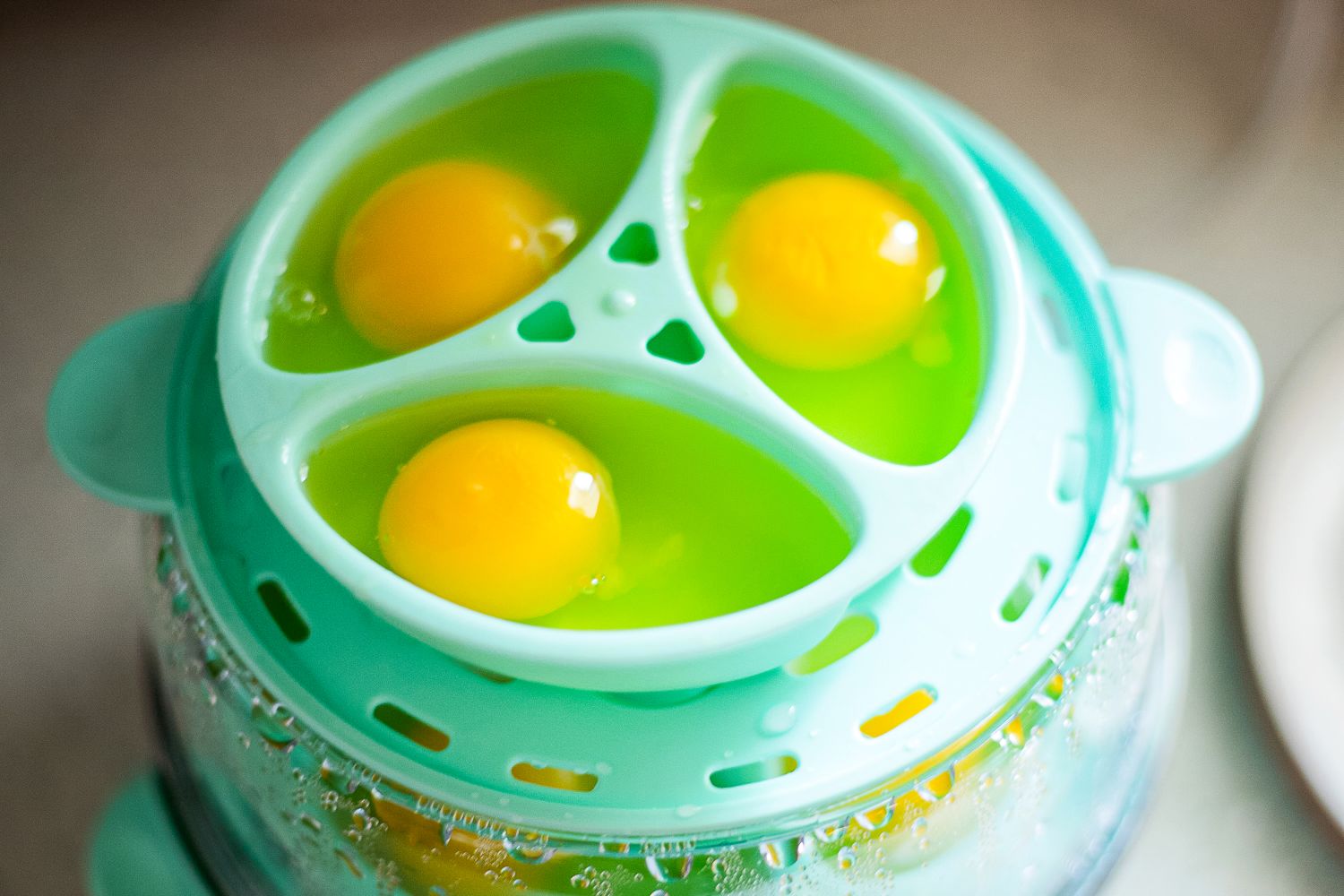 Cracked raw eggs in an egg cooker