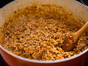 Pot of ragù bolognese with a wooden spoon