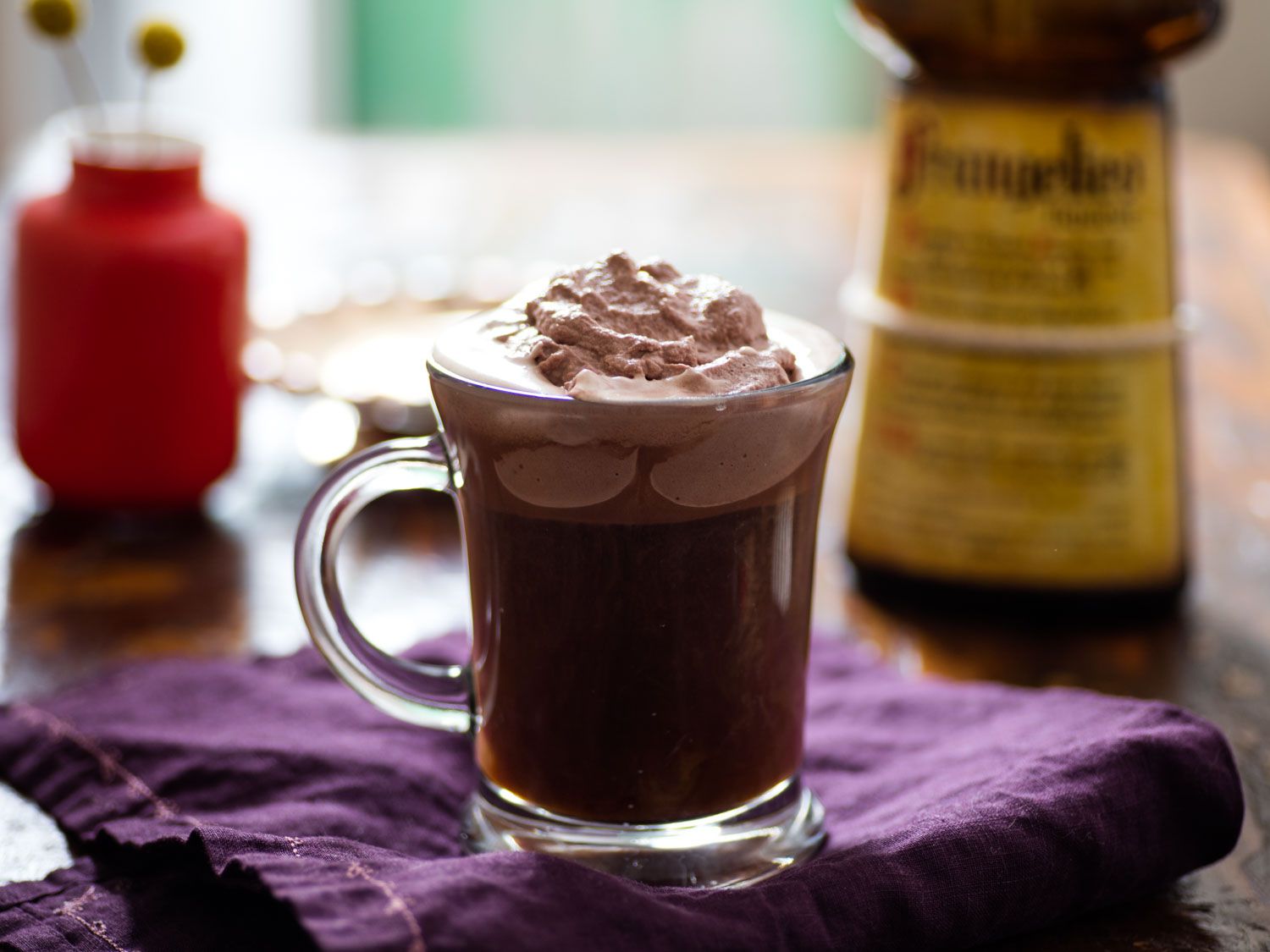 Glass mug filled with Frangelico-infused coffee, topped with thick layer of cocoa-flavored whipped cream