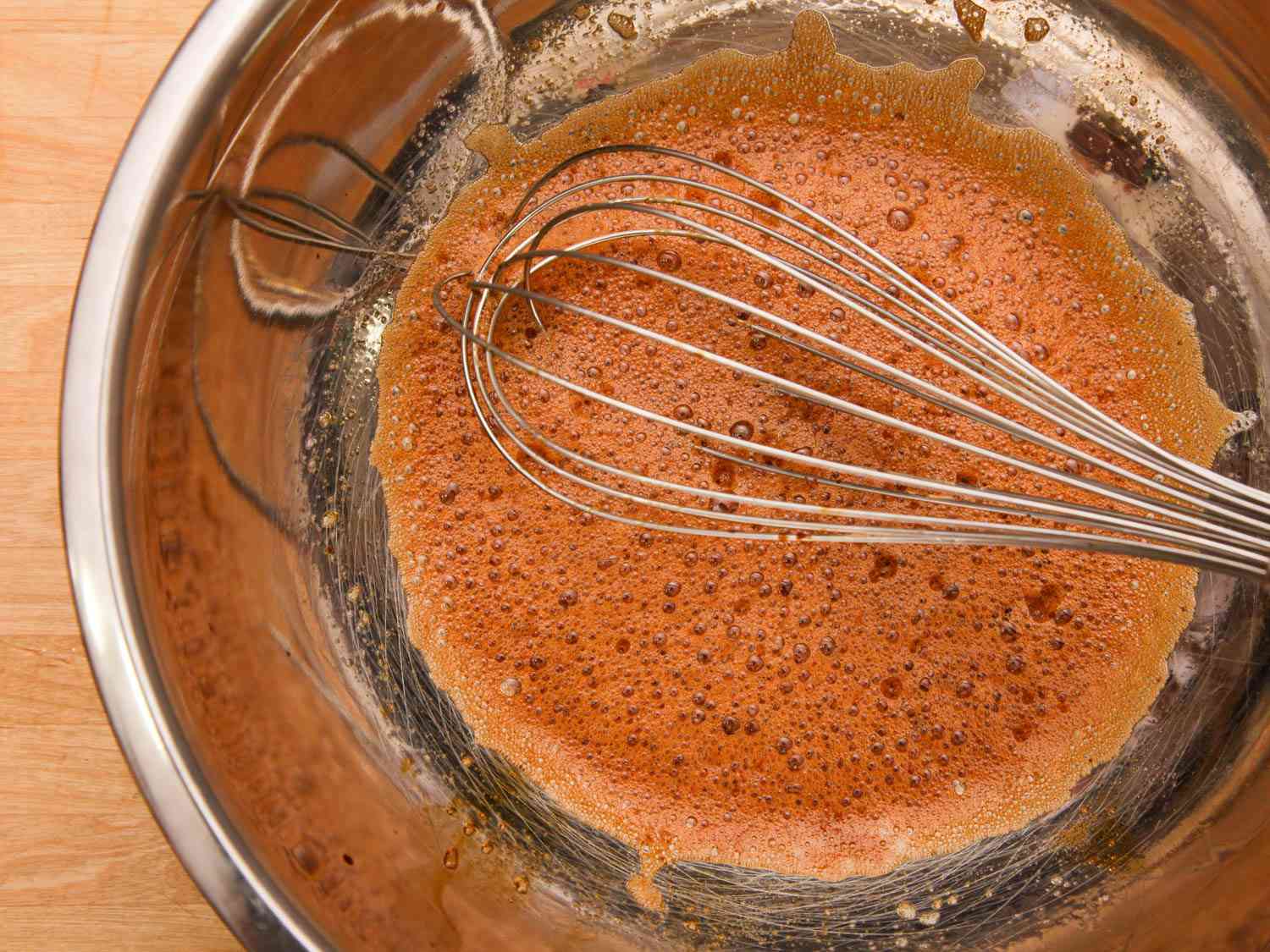 General Tso' chicken marinade in a large metal bowl with a whisk.
