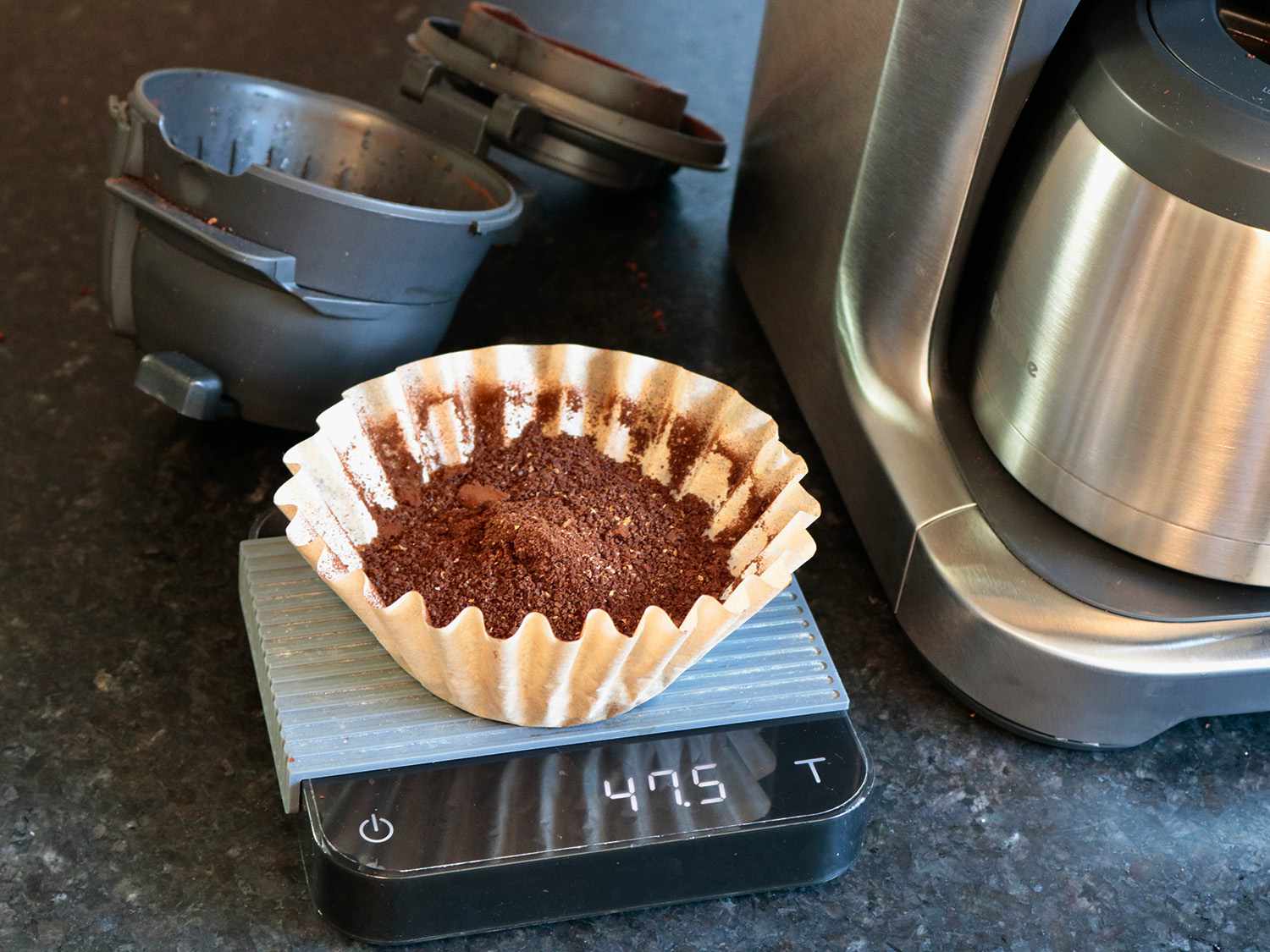 a coffee filter full of coffee sits on a scale reading 47.5 grams