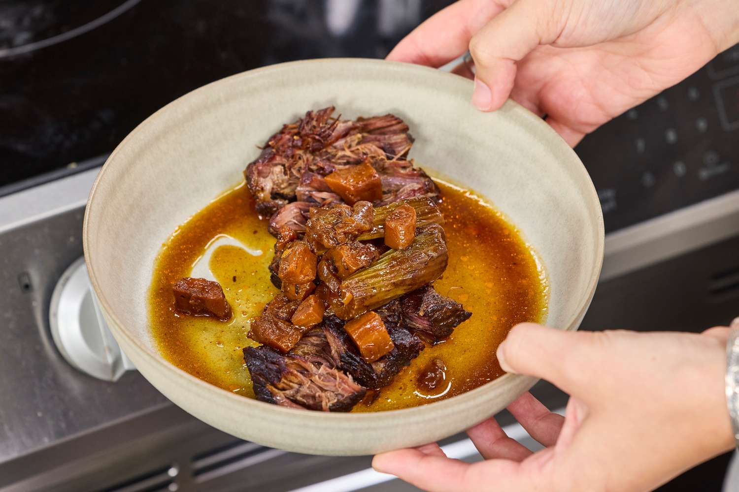 A bowl of braised beef with vegetables in a saucy broth cooked in the All American 10.5 Quart Pressure Cooker & Canner