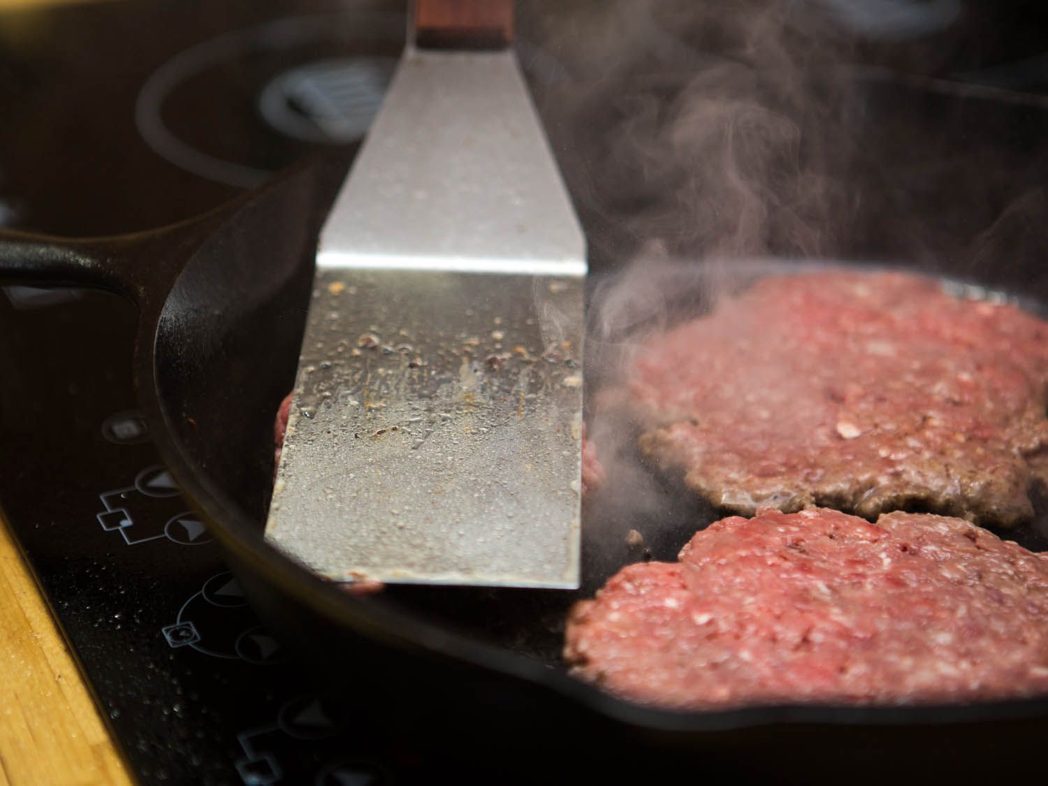 smashing burger patties to flatten