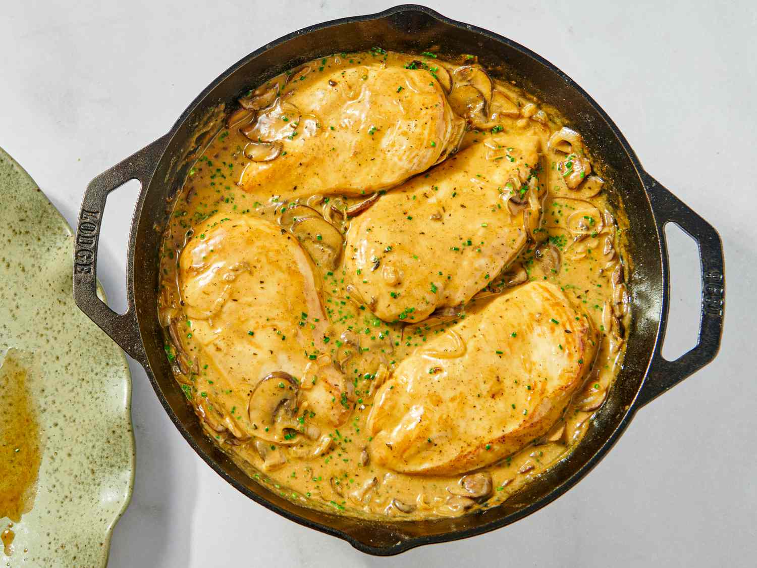 Chicken breasts in a skillet with a creamy mushroom sauce