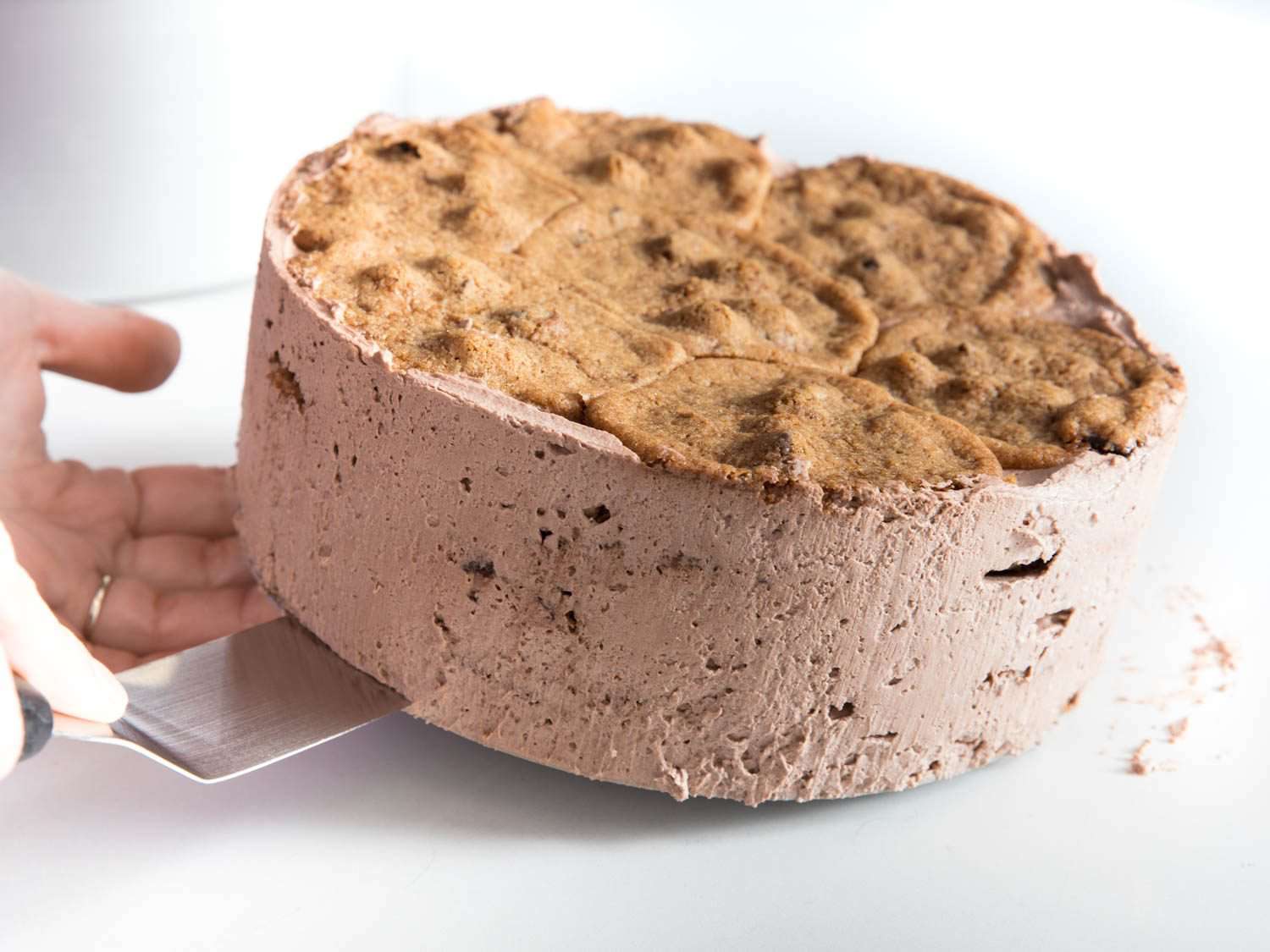 Transferring the icebox cake to a plate, using an offset spatula to lift it up