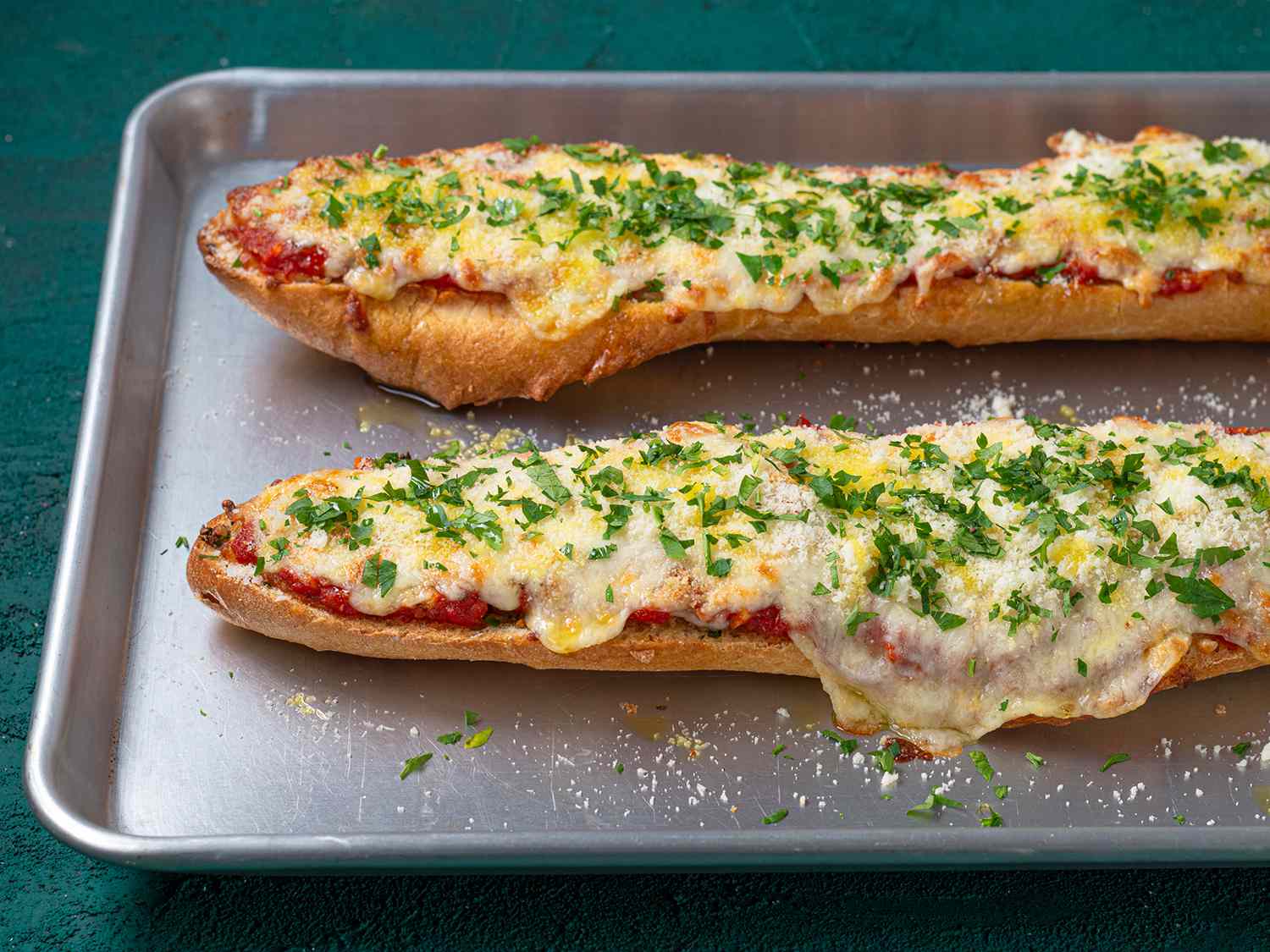 Finished french bread pizza on a baking sheet.
