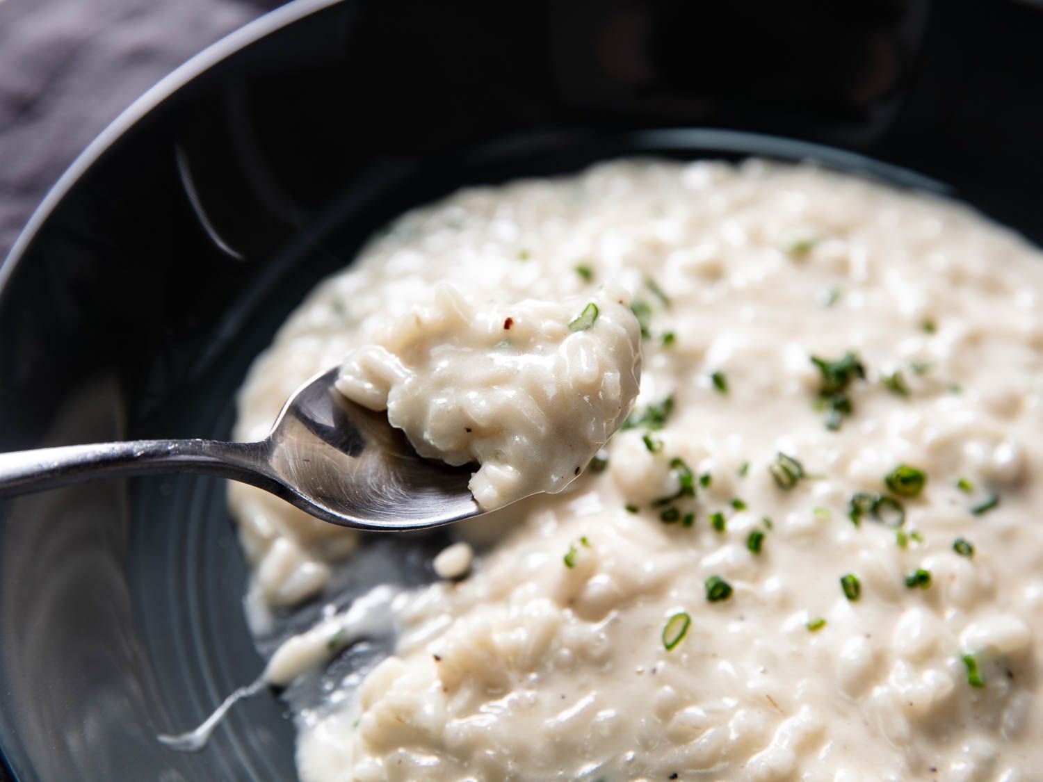 Spooning a bite of risotto from a plate