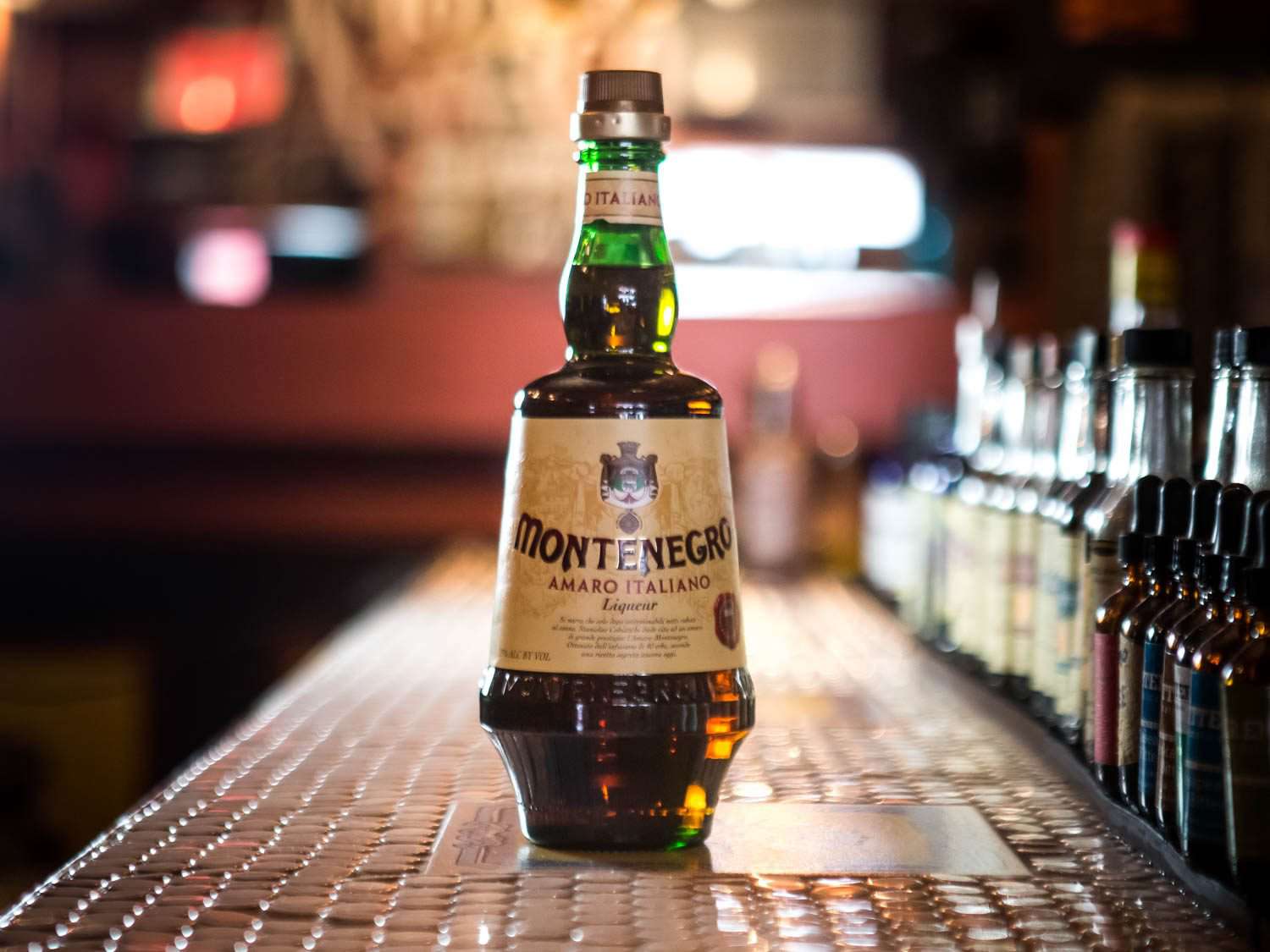 A bottle of Amaro Montenegro on a bar counter.