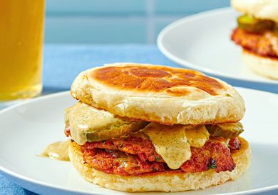 Turkey chourico smash burger on a plate with pickles and sauce between buns