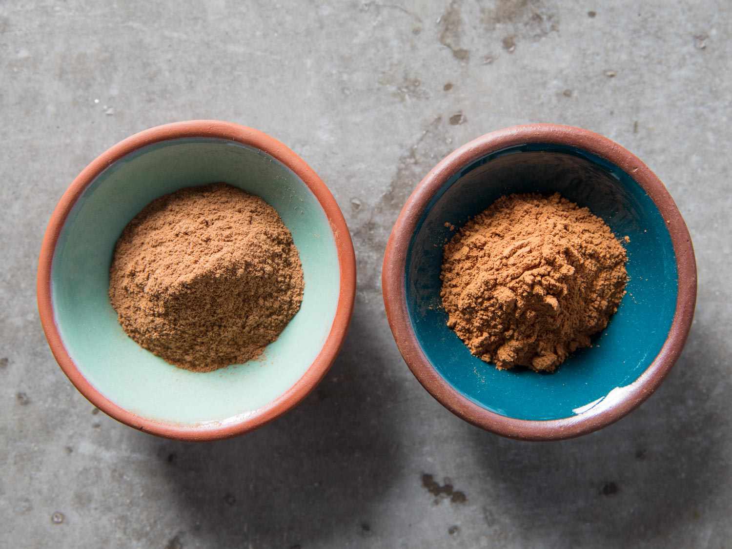 Two small bowls of cinnamon side by side. Ceylon cinnamon is on the left, and cassia cinnamon is on the right.