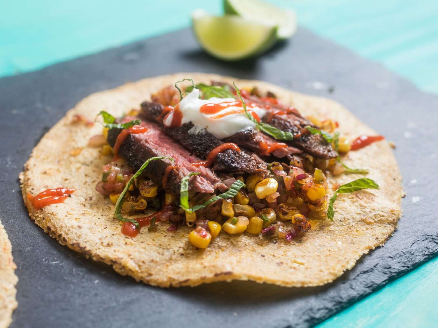 steak and corn taco on a slate board