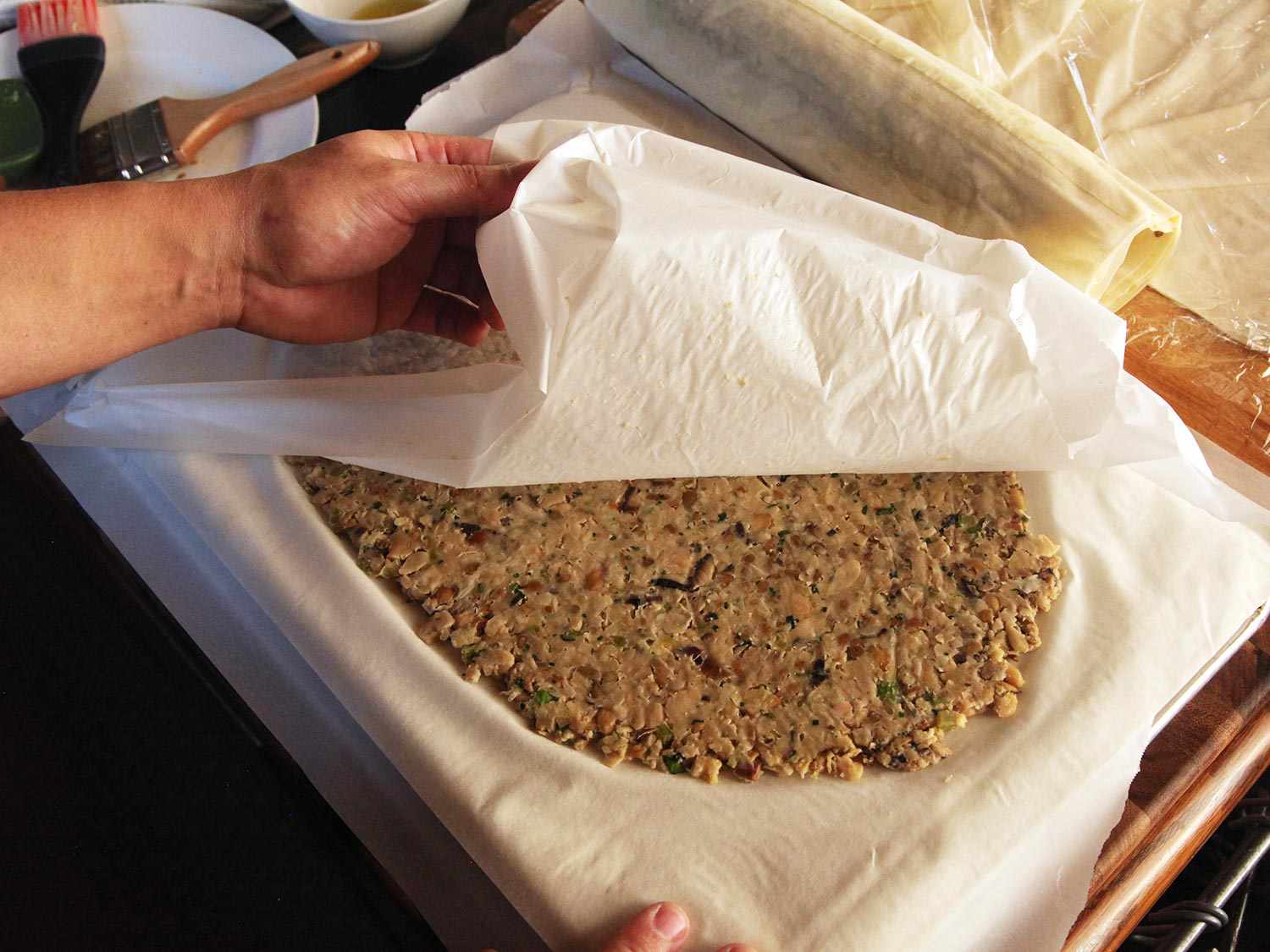 Removing parchment sheet from top of bean-cashew puree.