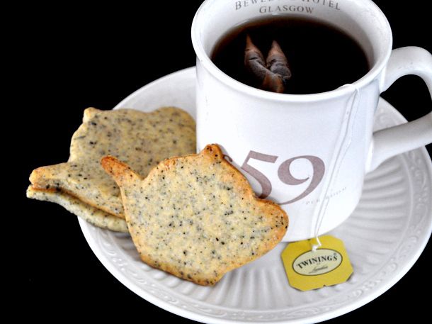 Earl grey tea cookies stacked on a saucer next to a mug of tea.