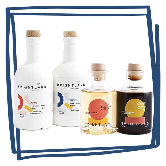 Four bottles of Brightland oils and vinegars displayed side by side featuring minimalist labels and capped with cork tops