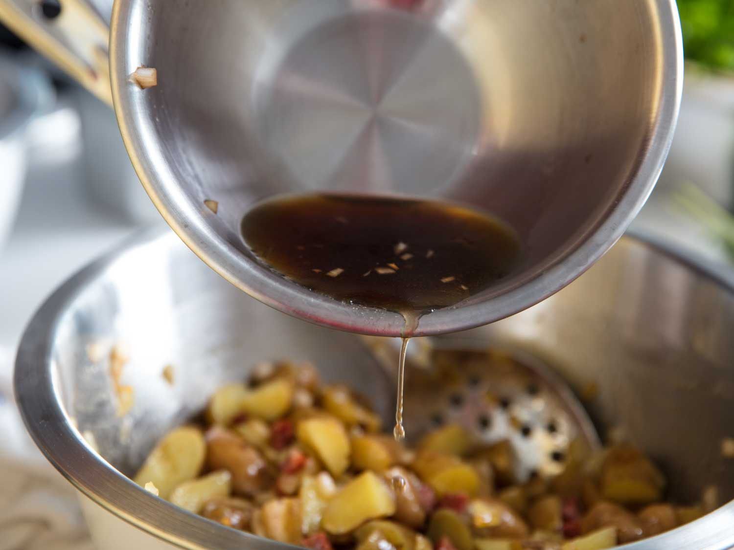 Adding sherry vinegar to fingerling potato salad.