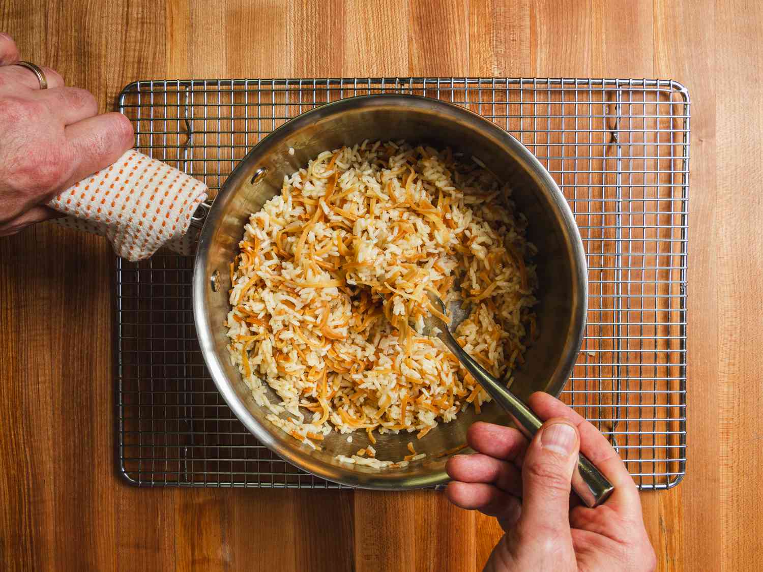 Rice pilaf being fluffed off heat