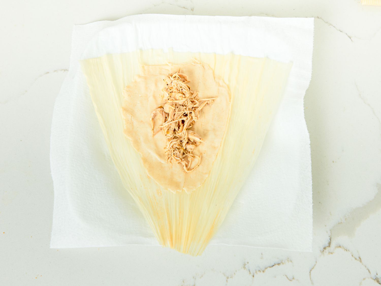 Overhead view of filling tamale with chicken