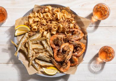 A large platter of fritto misto di mare with fried shrimp, squid, and smelt.