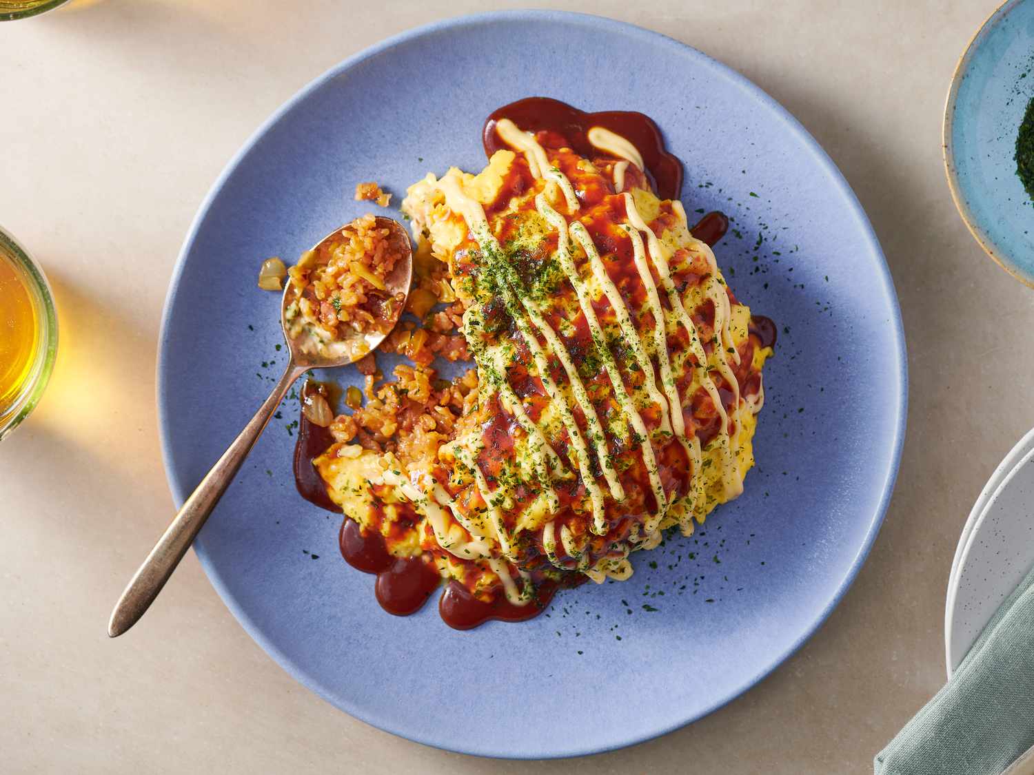 Omurice on a blue plate with a spoon