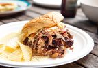 Low-and-slow pulled pork, sandwiched in a bun and served with wavy potato chips.