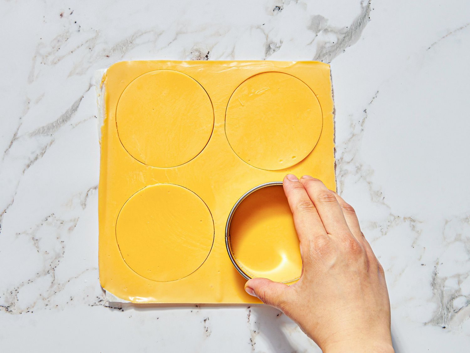 Overhead view of cutting out circles of cheese