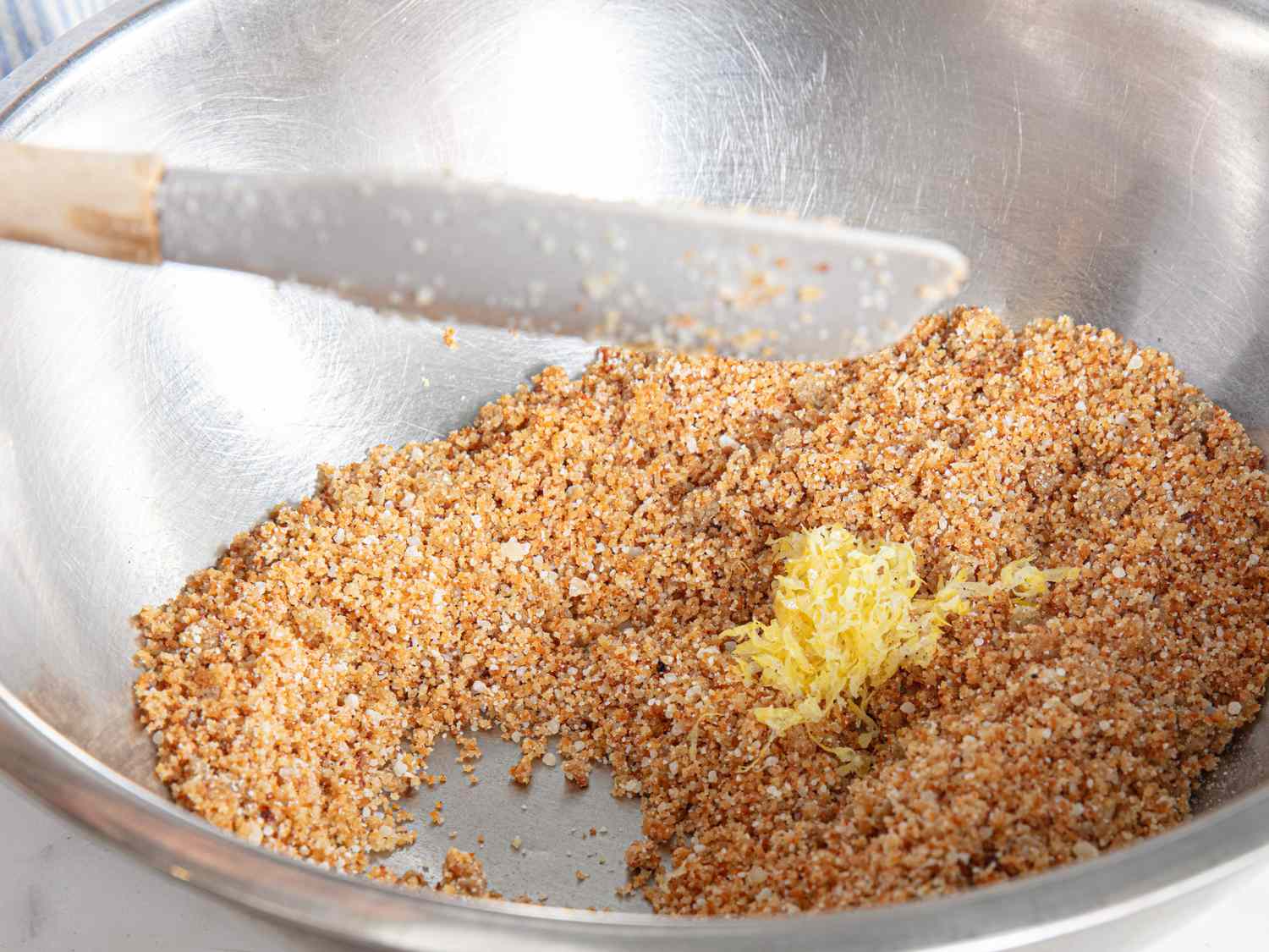 Overhead veiw of adding lemon zest to breadcrumbs