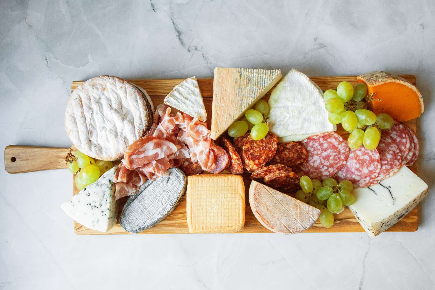 The Wiliams Sonoma charcuterie board, filled with meat, cheese, and grapes.