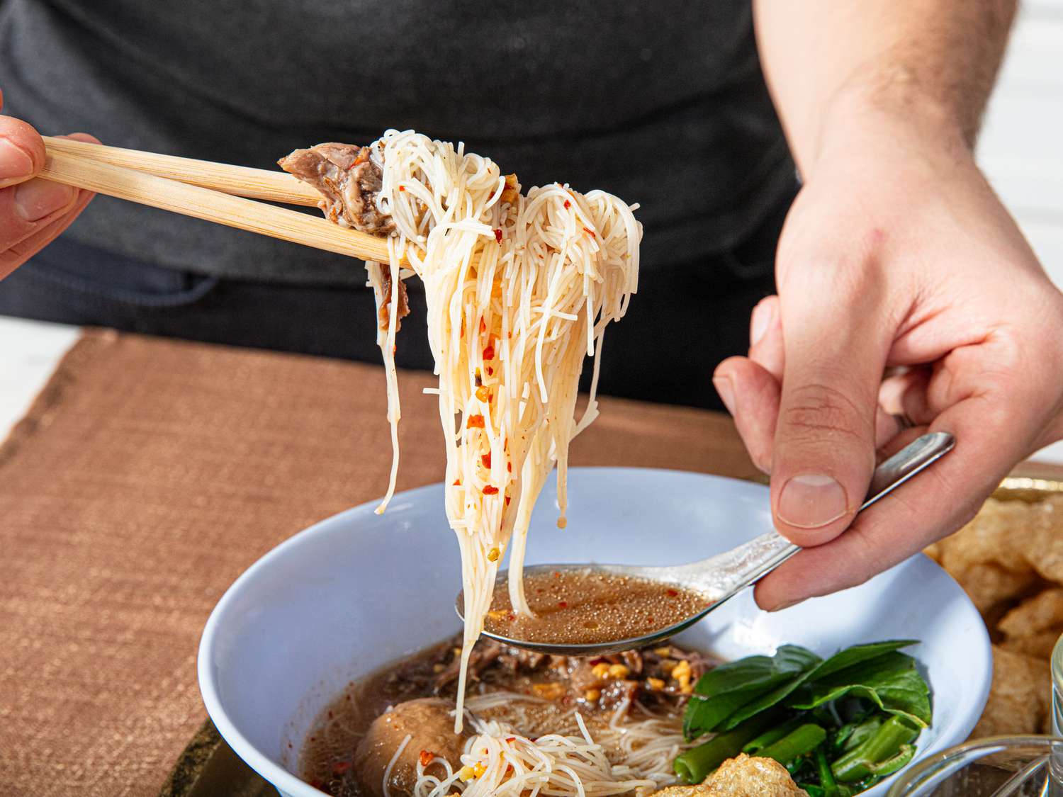 Side view of eating boat noodle soup