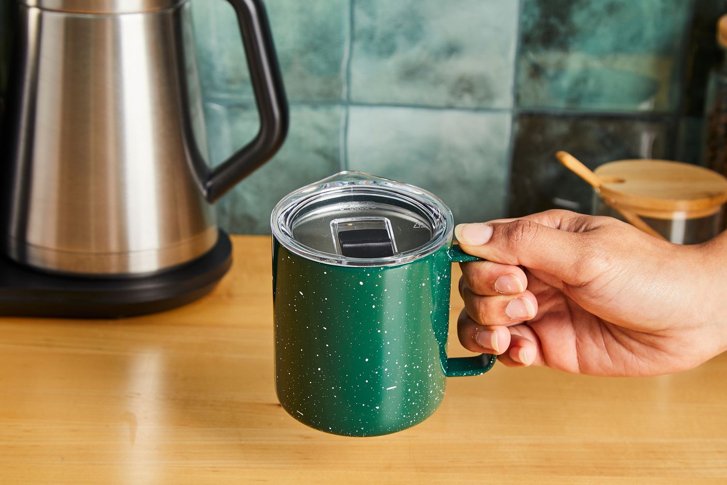 A person holding the MiiR travel cup's handle.