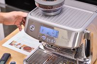 A person turns a dial on the Breville The Barista Pro Espresso Machine