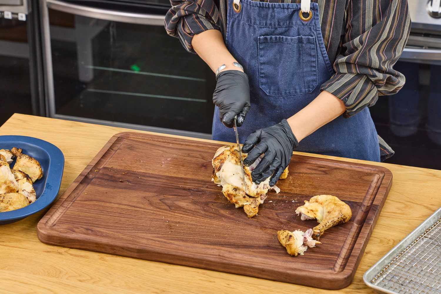 Person carving cooked chicken on a Virginia Boys Kitchens Walnut Wood Cutting Board