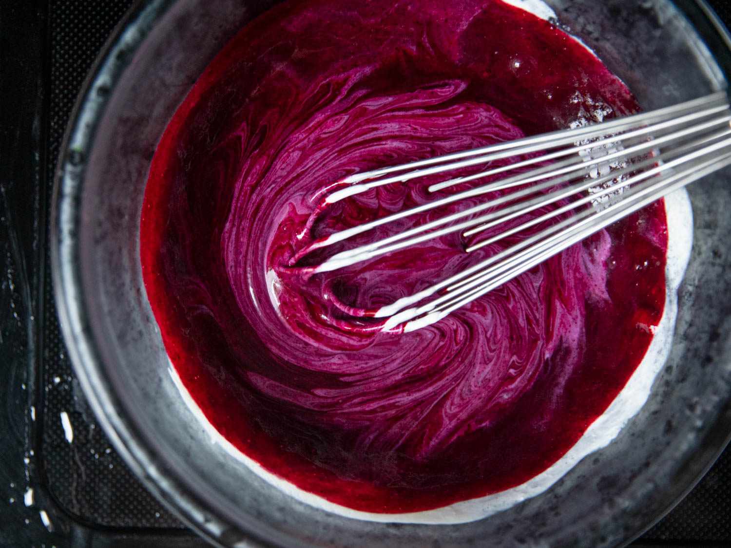 Whisking blueberry purée into yogurt base to thoroughly combine.