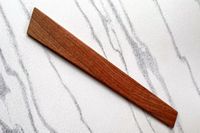 A flat wooden tool placed on a smooth countertop