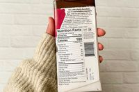A person holding Theo Pure Dark 85% Chocolate Bar showing the nutrition facts