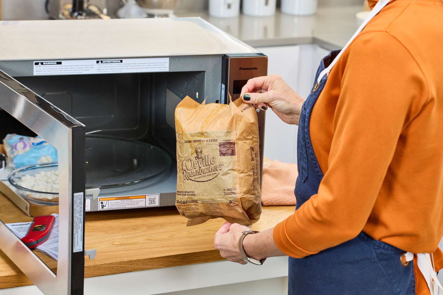 A person taking a bag of popcorn out of the Panasonic Oven with Cyclonic Wave Inverter Technology
