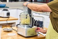 A person uses the Magimix 14-Cup Food Processor
