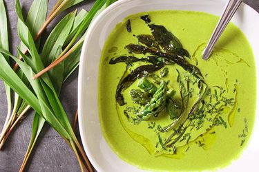 Overhead view of Asparagus and Ramp Soup With Yogurt, served in a white bowl.