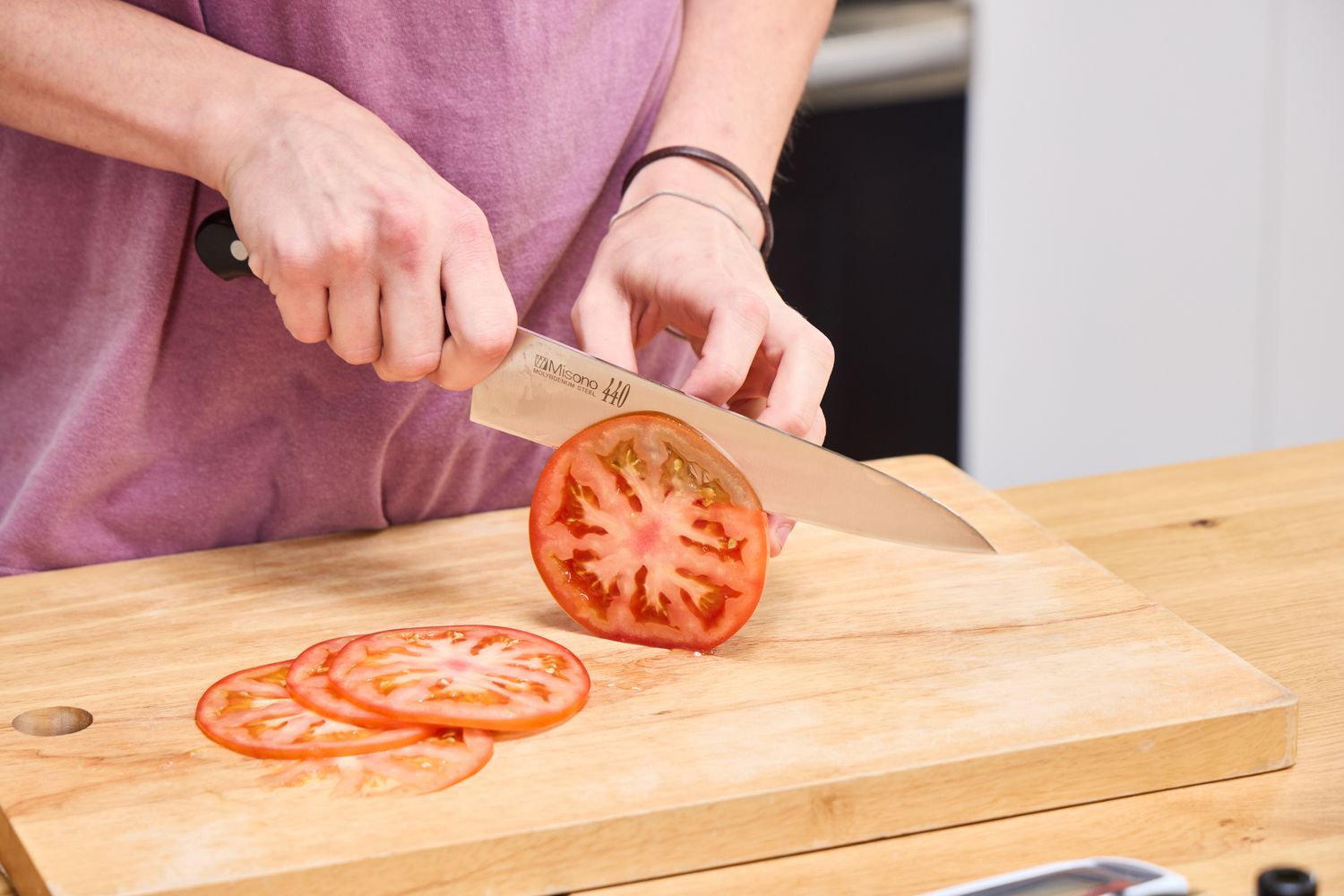 A person slices tomato using the Misono 8.2 Inch Molybdenum Gyutou