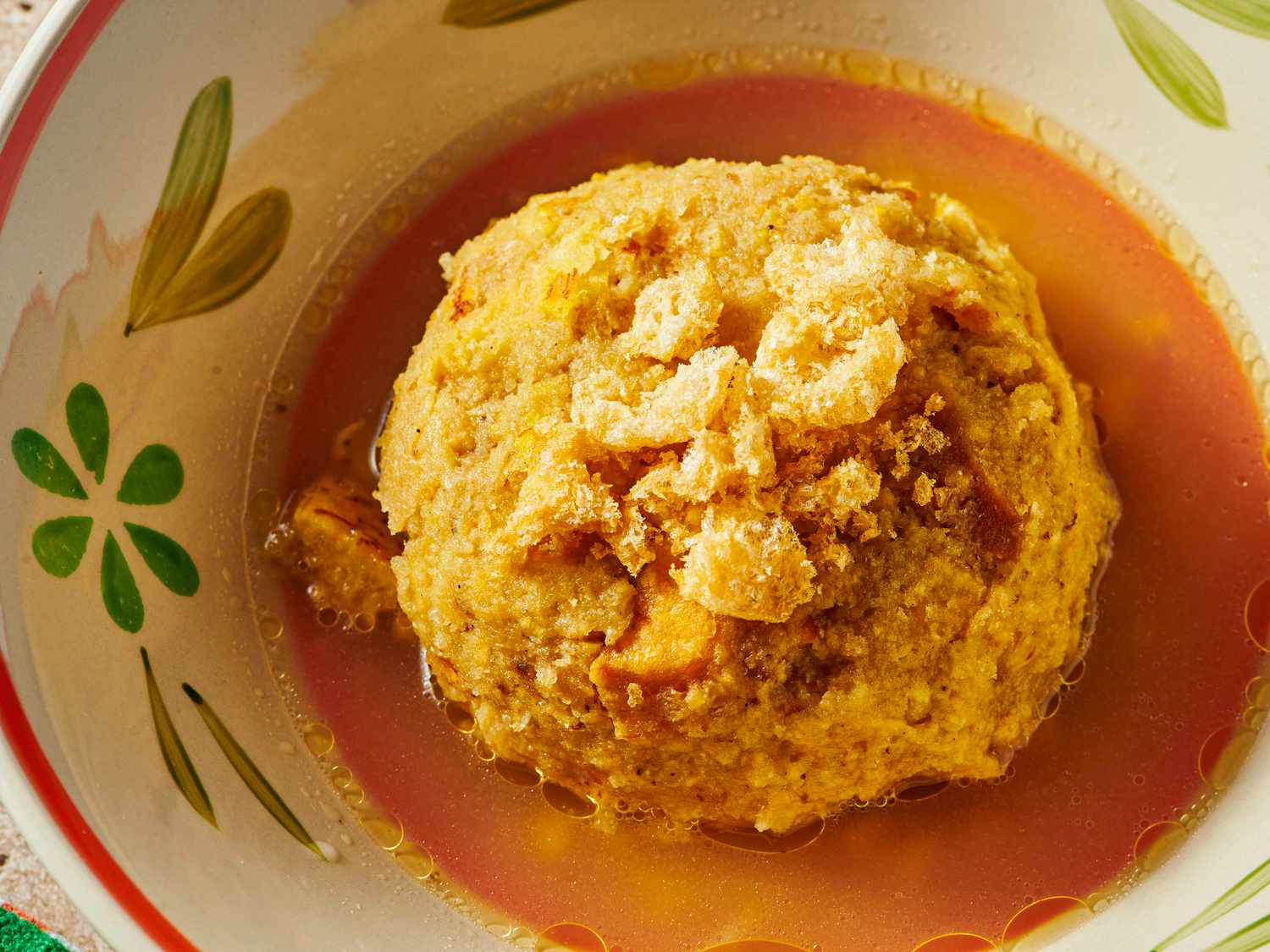 Overhead angle of mofongo in a bone colored bowl with flowers 