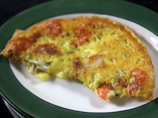 Bánh xèo resting on a white and green plate