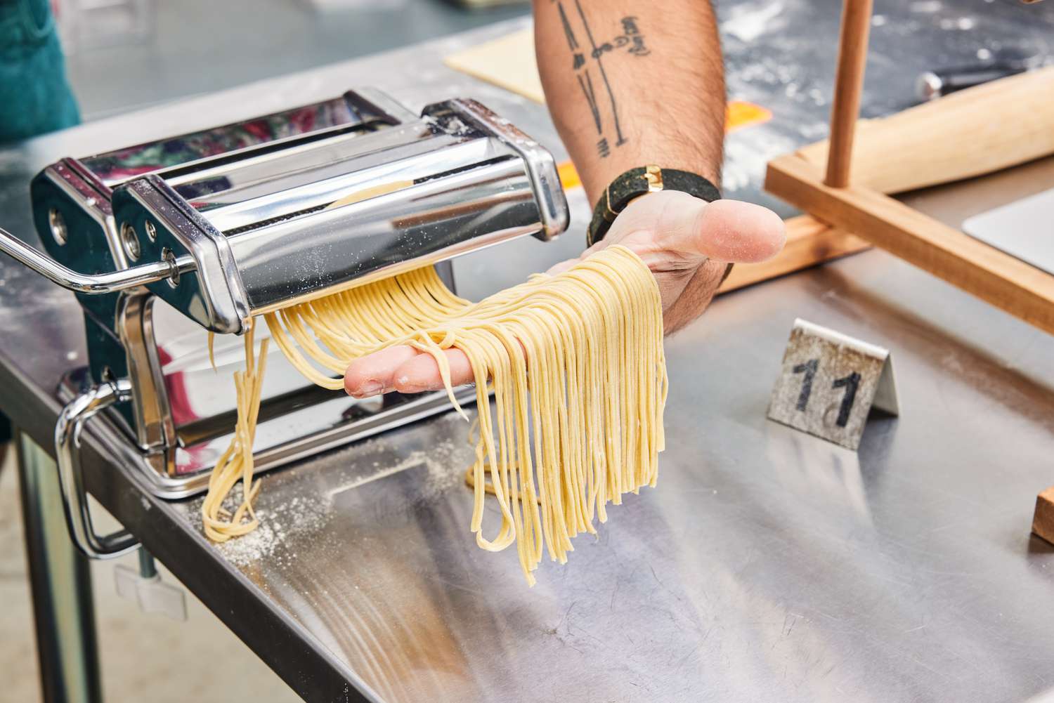 Thin strands of pasta coming out of a manual pasta maker