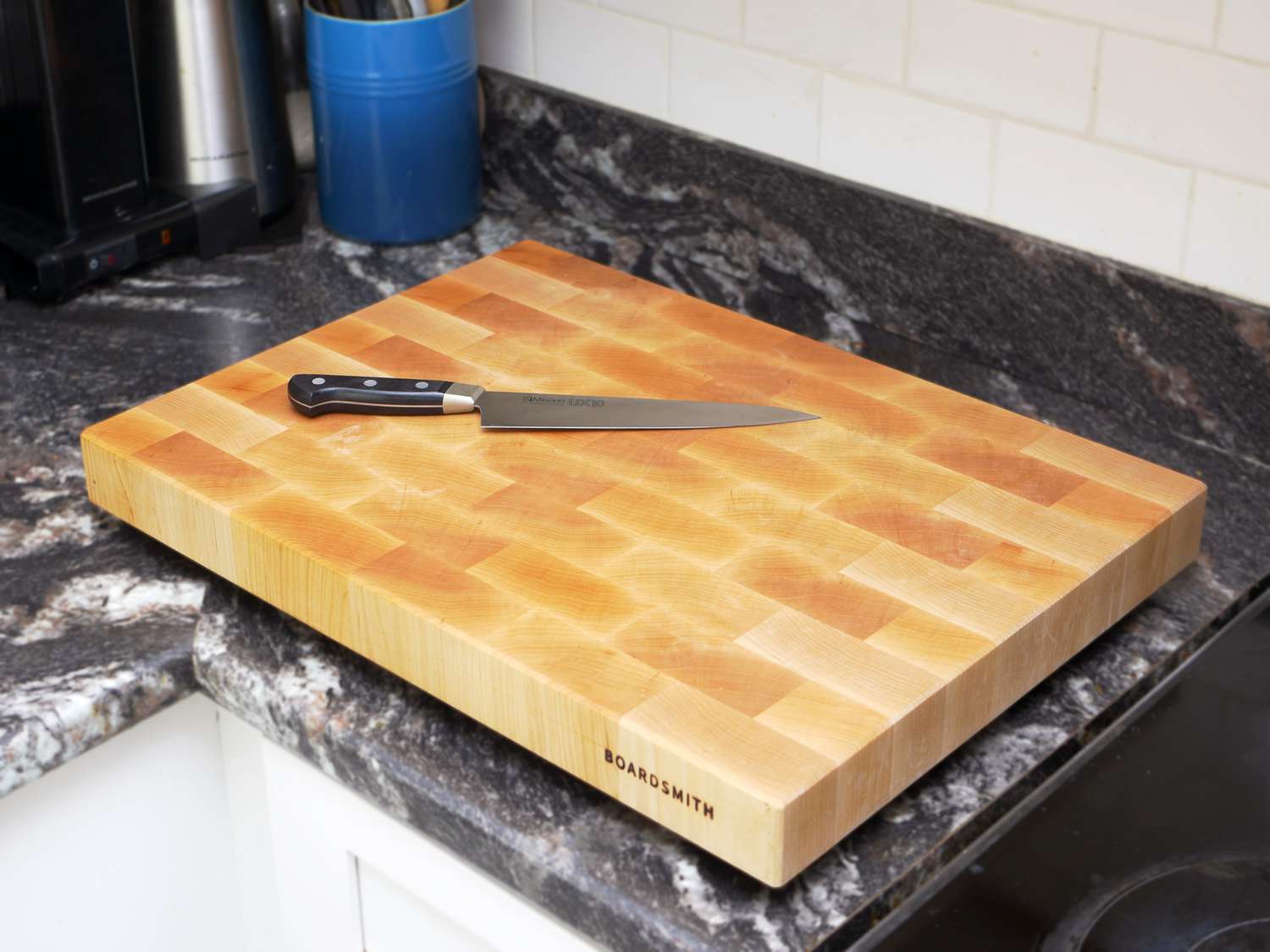 Boardsmith cutting board on a countertop with a chef's knife on the board