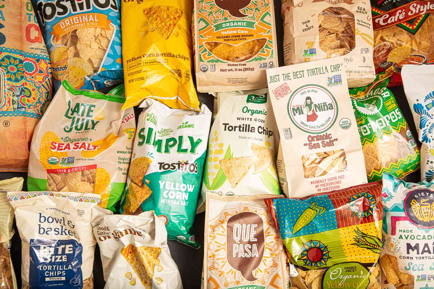 A variety of tortilla chip brands in colorful packaging arranged together