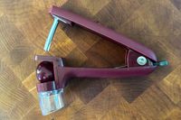 The OXO cherry pitter on a wooden cutting board
