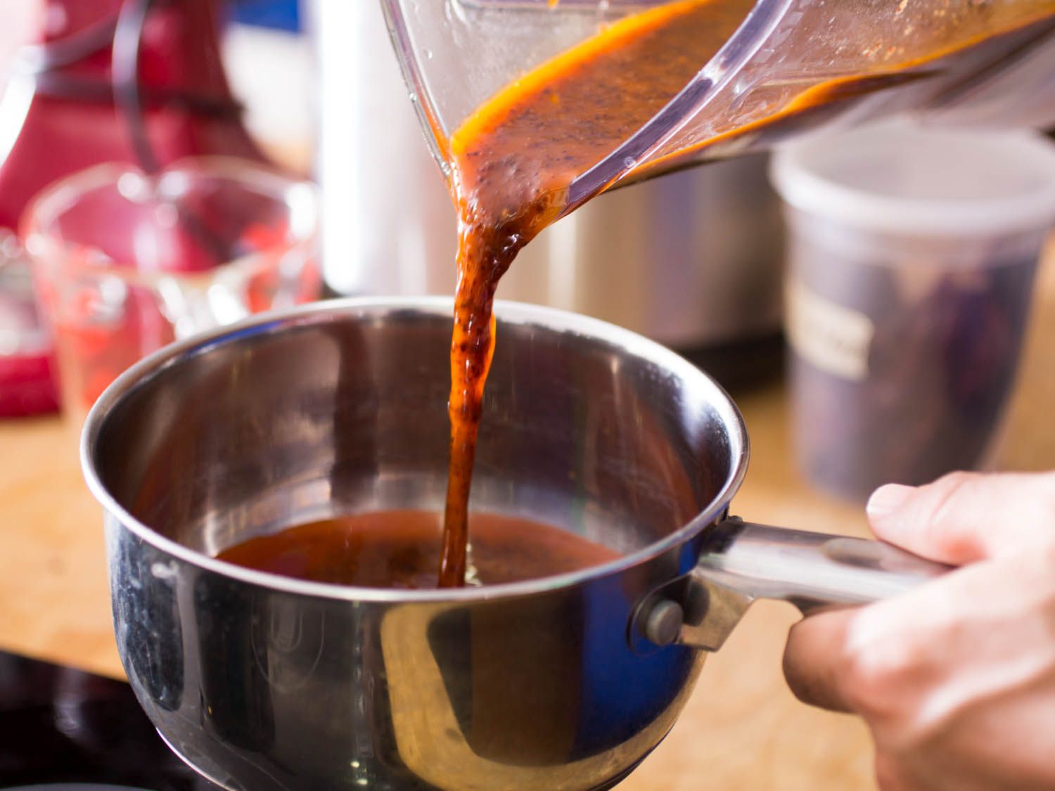 Pouring blended chile oil into a saucepan