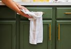 A person drying their hands with the All-Clad Kitchen towel.